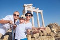 Positive young family take a selfie photo near antique ÃÂolonnade